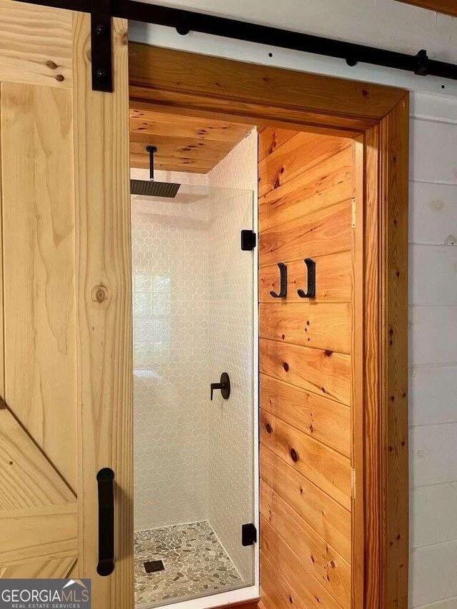 bathroom featuring wood walls and a shower