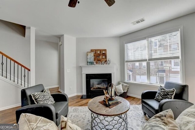 living room featuring ceiling fan and hardwood / wood-style flooring