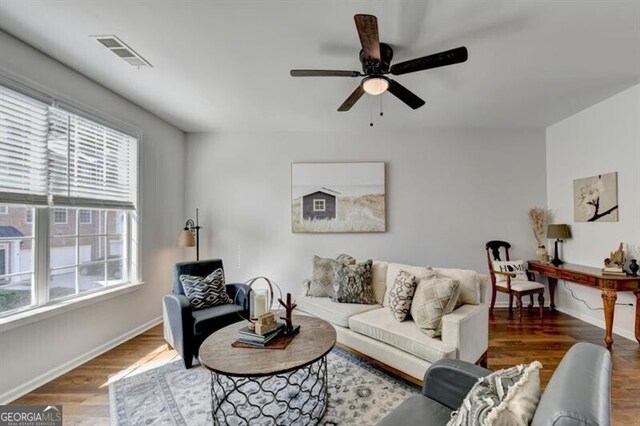 living room featuring dark hardwood / wood-style flooring, a wealth of natural light, and ceiling fan