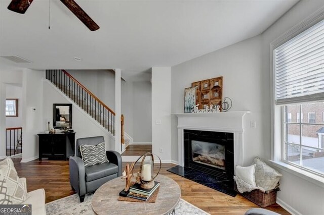 living room featuring wood-type flooring and ceiling fan