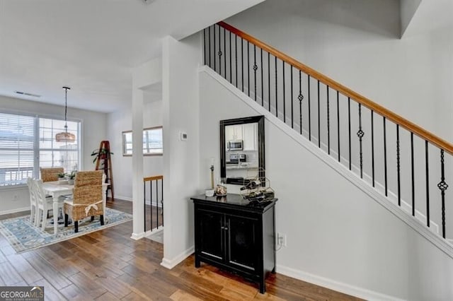 stairs with a chandelier and hardwood / wood-style floors