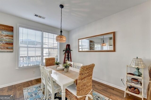 dining room with a wealth of natural light and dark hardwood / wood-style flooring