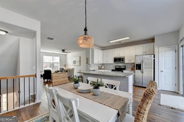 dining space featuring ceiling fan and dark wood-type flooring