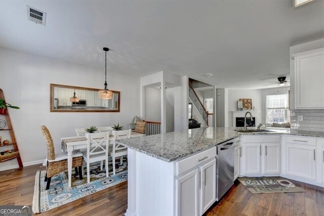 kitchen with ceiling fan, sink, white cabinetry, dishwasher, and dark hardwood / wood-style flooring