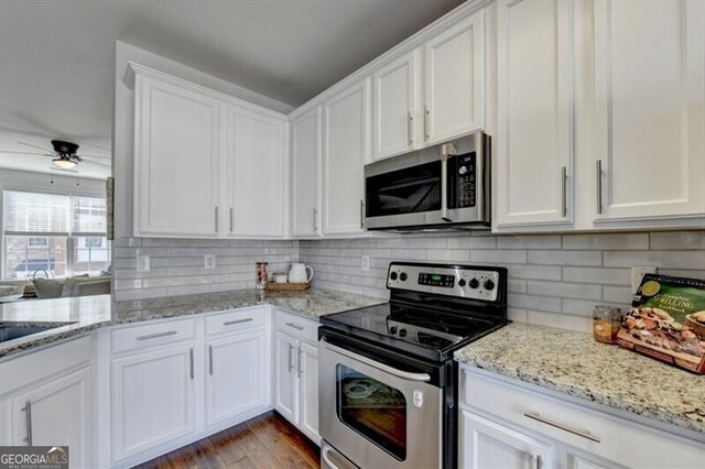 kitchen featuring appliances with stainless steel finishes, ceiling fan, white cabinetry, and dark hardwood / wood-style floors