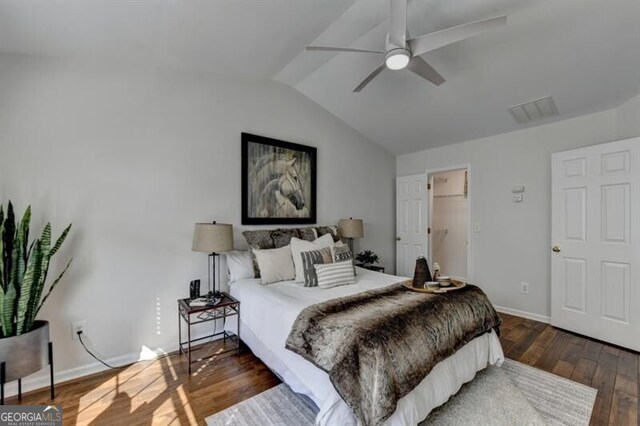 bedroom with dark wood-type flooring, vaulted ceiling, and ceiling fan