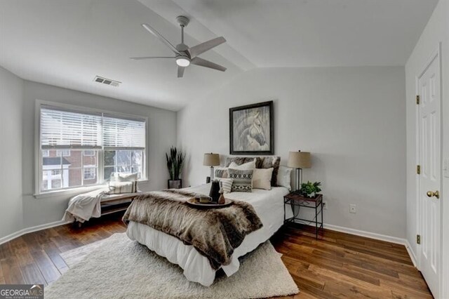 bedroom featuring dark wood-type flooring, vaulted ceiling, and ceiling fan