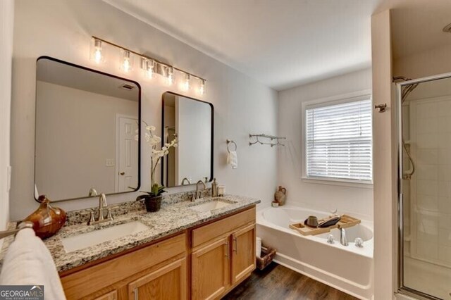 bathroom featuring hardwood / wood-style flooring, vanity, and shower with separate bathtub