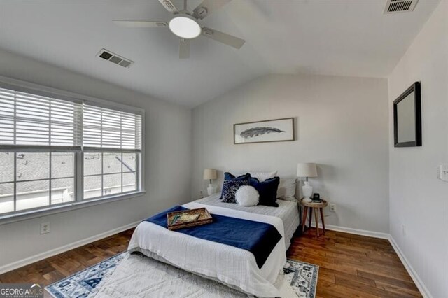 bedroom featuring dark wood-type flooring, vaulted ceiling, and ceiling fan