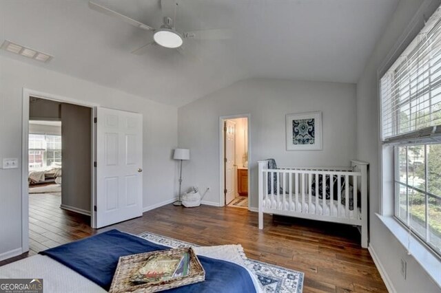 bedroom featuring vaulted ceiling, dark hardwood / wood-style flooring, multiple windows, and ceiling fan