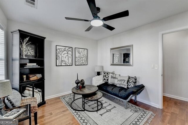 living room with ceiling fan and hardwood / wood-style flooring