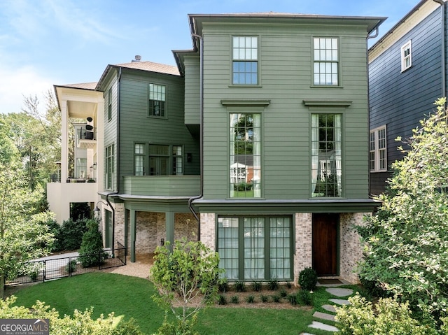 view of front of house featuring a front yard and a balcony