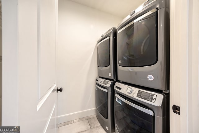 laundry room with light tile patterned floors and stacked washer / drying machine