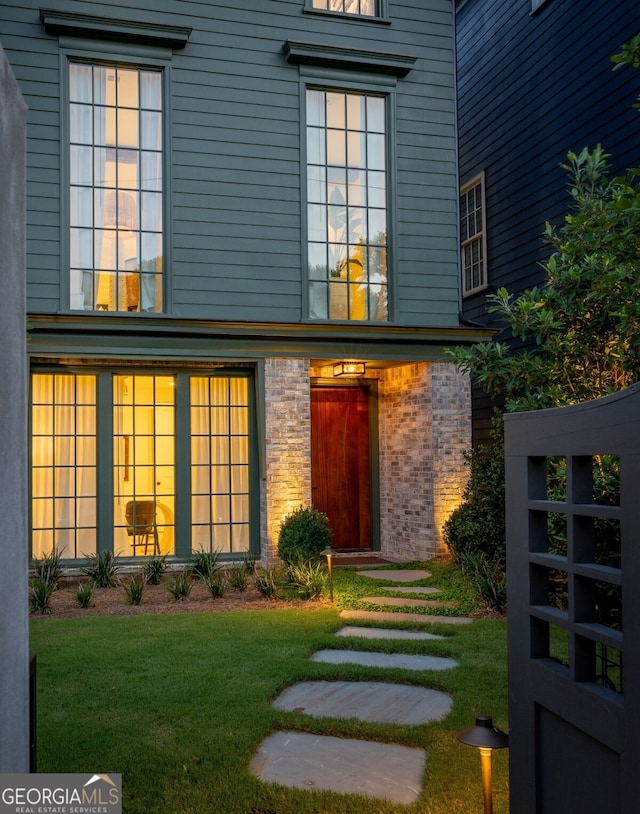 property entrance with a lawn