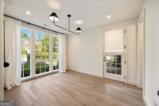 unfurnished dining area featuring light wood-type flooring and a wealth of natural light