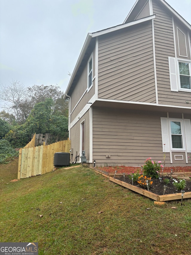 view of side of home with a lawn and central air condition unit