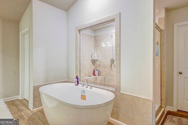 bathroom with wood-type flooring and independent shower and bath