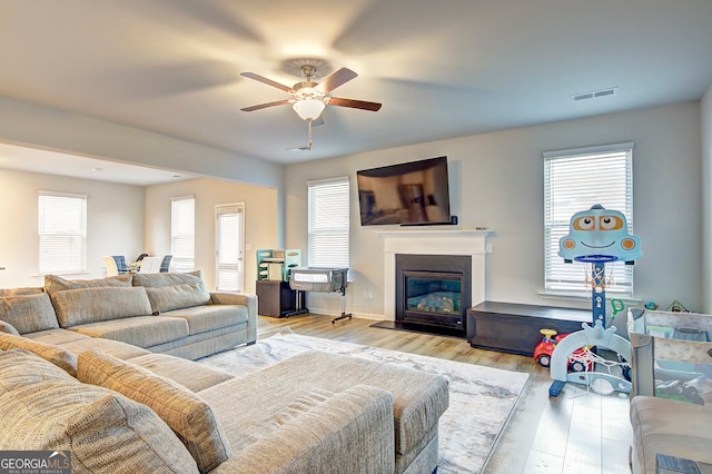 living room with ceiling fan and light wood-type flooring