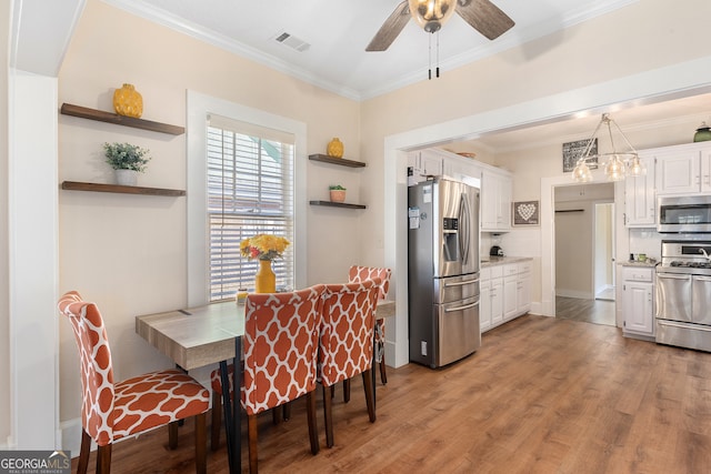 dining space featuring crown molding, hardwood / wood-style floors, and ceiling fan