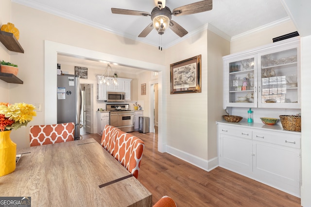 dining area with ceiling fan with notable chandelier, light hardwood / wood-style flooring, and crown molding