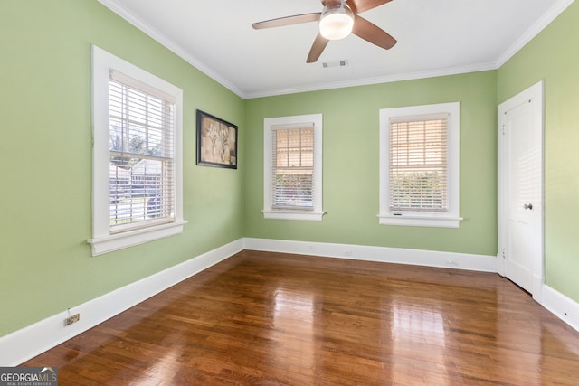 empty room featuring crown molding, plenty of natural light, and hardwood / wood-style floors