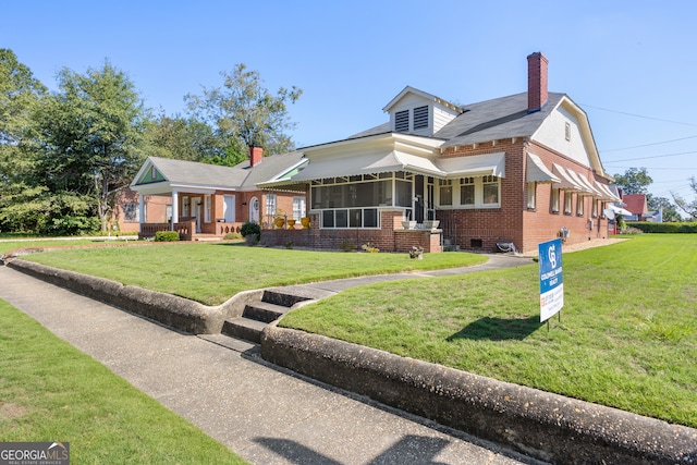 view of front of house featuring a sunroom and a front lawn