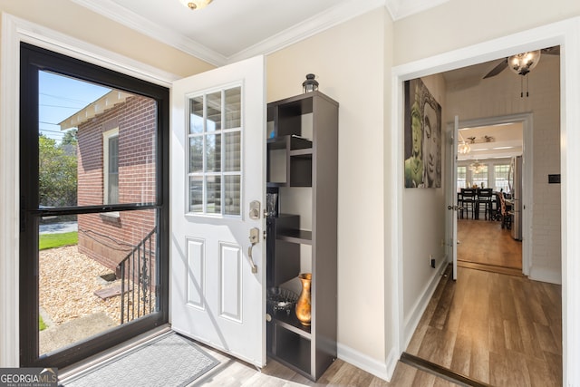 doorway to outside with ceiling fan, hardwood / wood-style flooring, and ornamental molding