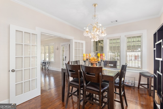 dining space with a chandelier, plenty of natural light, crown molding, and dark hardwood / wood-style flooring