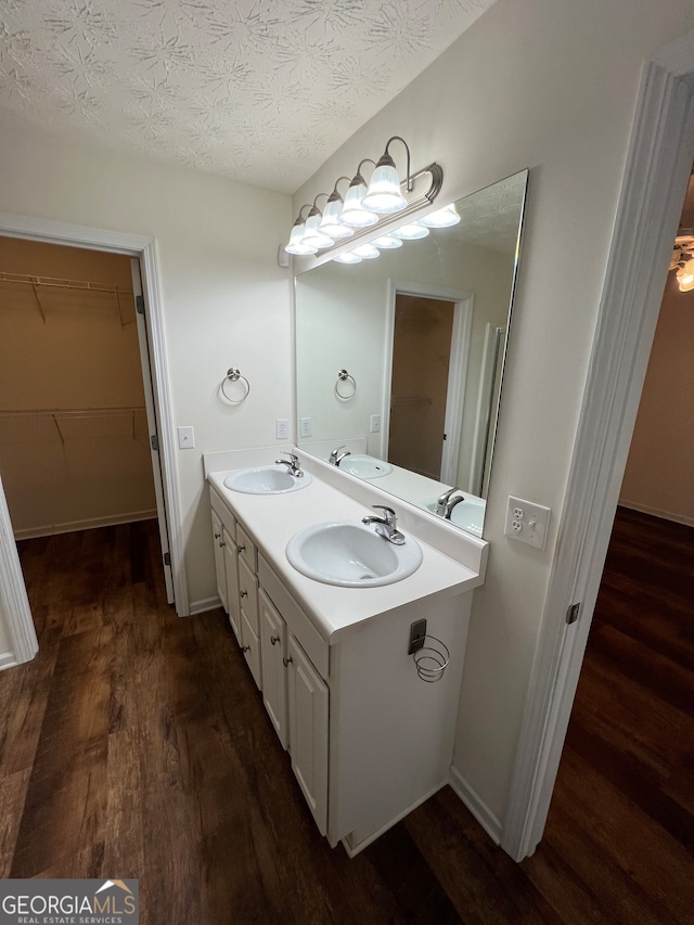 bathroom with wood-type flooring, a textured ceiling, and vanity