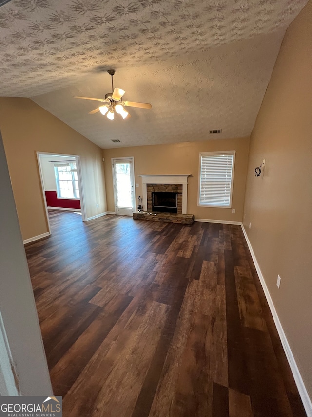 unfurnished living room with lofted ceiling, dark hardwood / wood-style floors, and a textured ceiling