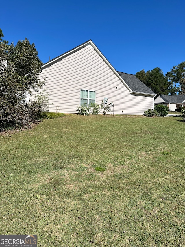 view of side of home with a lawn