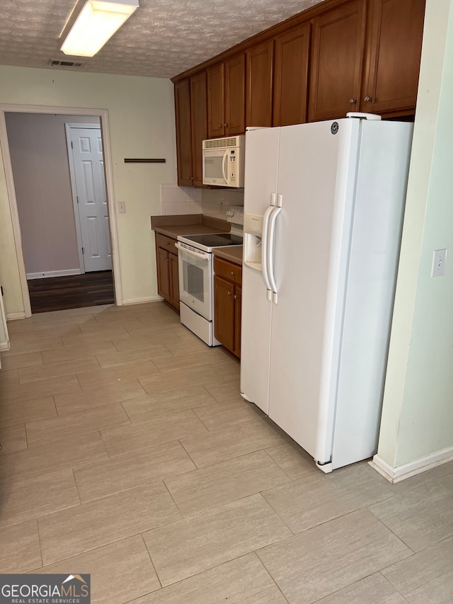 kitchen featuring white appliances and a textured ceiling