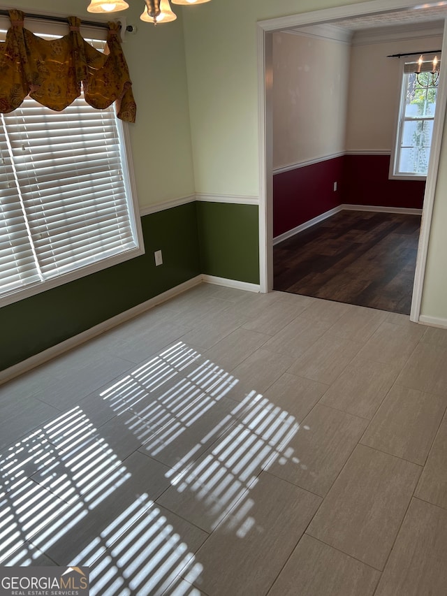 spare room featuring an inviting chandelier and hardwood / wood-style floors