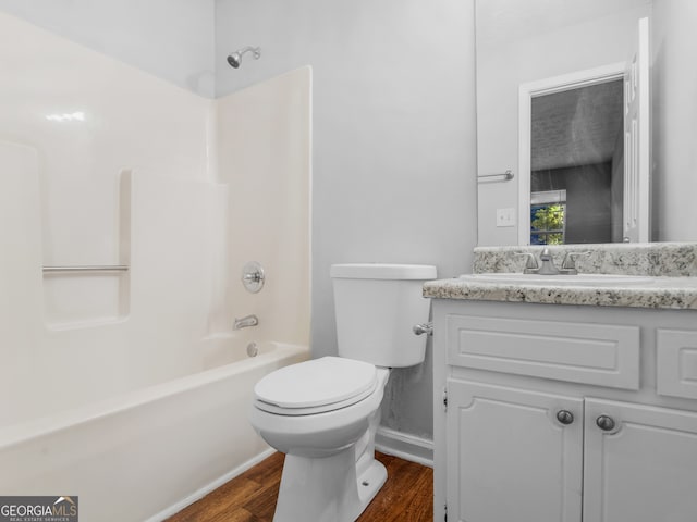 full bathroom with toilet, hardwood / wood-style flooring, vanity, and tub / shower combination