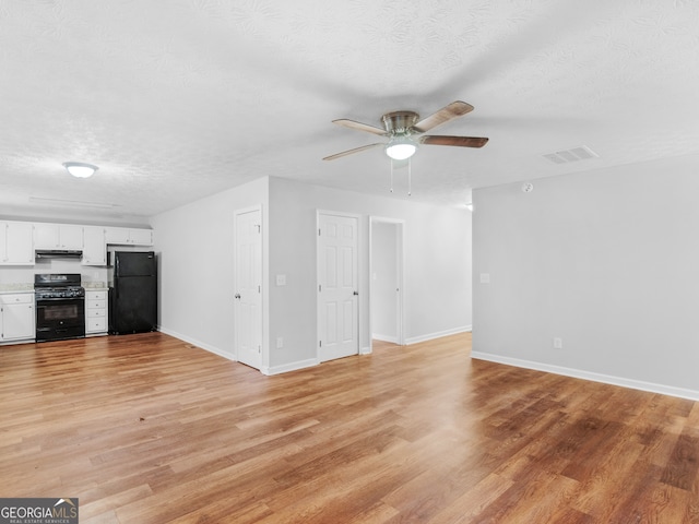 unfurnished living room with ceiling fan, a textured ceiling, and light wood-type flooring