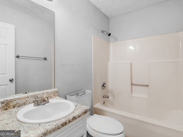 full bathroom featuring vanity, shower / washtub combination, a textured ceiling, and toilet