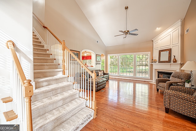 living room with high vaulted ceiling, light wood-type flooring, and ceiling fan