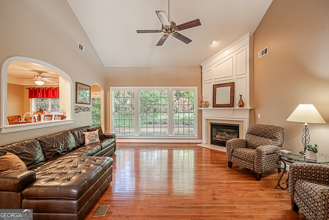 living room with high vaulted ceiling, ceiling fan, and light hardwood / wood-style flooring