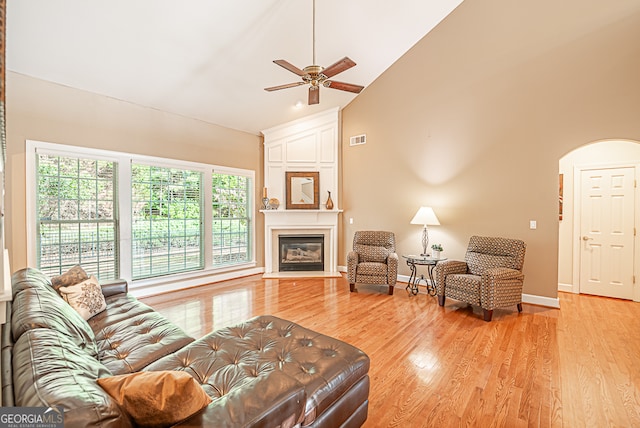 living room with light wood-type flooring, high vaulted ceiling, and ceiling fan