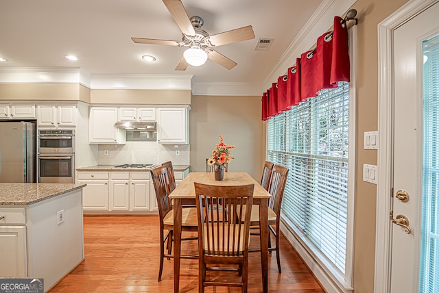 dining room with crown molding, light wood-type flooring, and ceiling fan