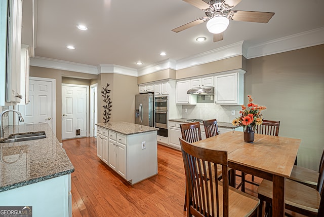 kitchen featuring light hardwood / wood-style floors, dark stone counters, sink, white cabinets, and appliances with stainless steel finishes