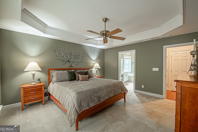 carpeted bedroom with ceiling fan, ensuite bathroom, crown molding, and a tray ceiling