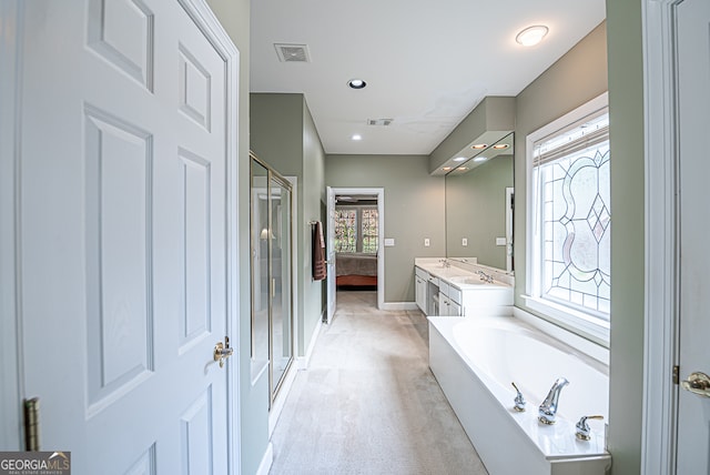 bathroom featuring separate shower and tub and vanity