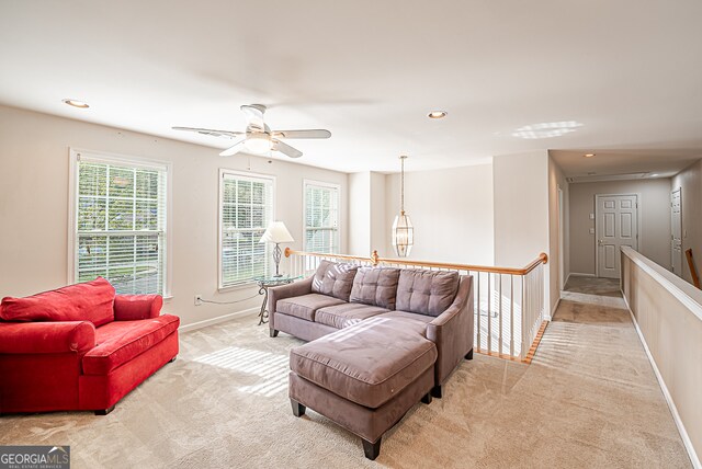 carpeted living room with ceiling fan