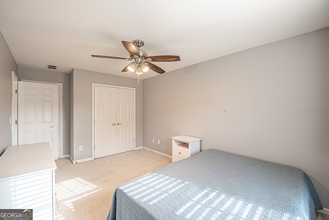 carpeted bedroom featuring ceiling fan and a closet