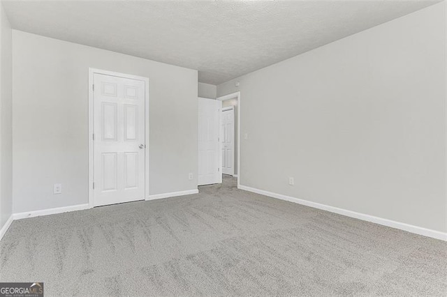 unfurnished bedroom featuring light carpet and a textured ceiling