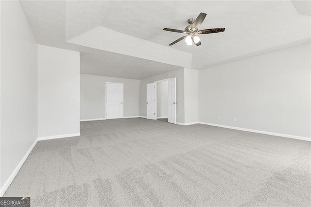 carpeted spare room featuring ceiling fan and a textured ceiling