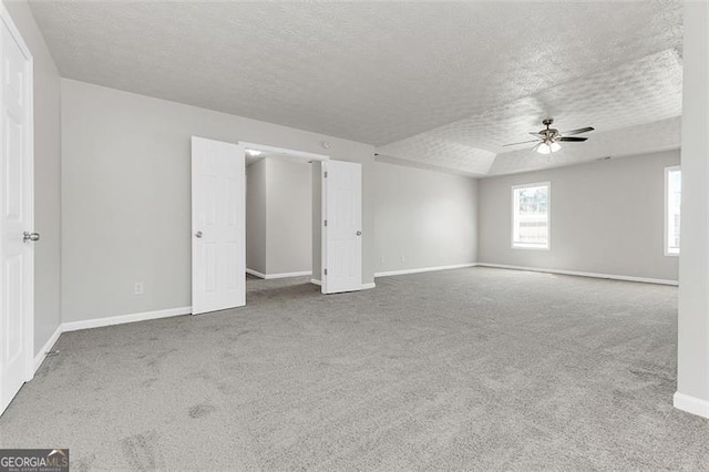 carpeted empty room featuring ceiling fan and a textured ceiling