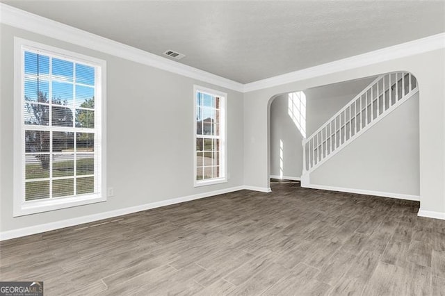 spare room with plenty of natural light, ornamental molding, and hardwood / wood-style flooring