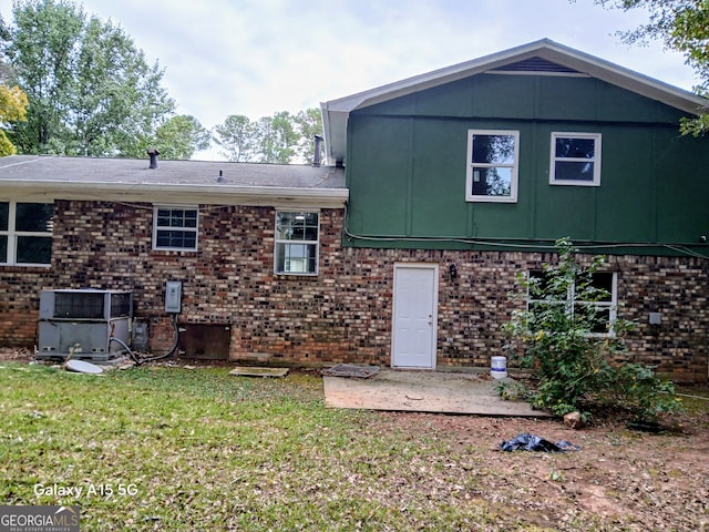 back of house featuring a yard and central AC